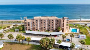 A multi-story hotel with a pool and a beach view. - Beach, Don’t Kill My Vibe (Ormond Beach)