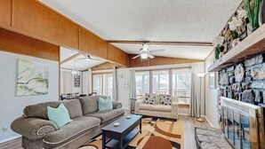 A spacious living room with a large sofa, a coffee table, and a fireplace.