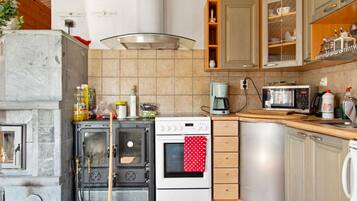 Een koelkast, een magnetron, een vaatwasser, kookgerei, borden en bestek