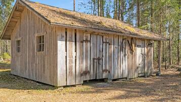 A rustic wooden cabin with a sloped roof, large windows, and a door.