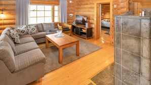 A cozy log cabin interior with a living room, sofa, TV, and a small dining area. - Paloniemi by Interhome (Savitaipale)