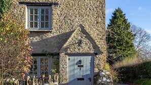 Une maison en pierre avec une fenêtre, une porte et un petit porche.