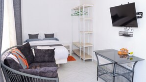 Une chambre moderne avec un lit, un canapé, une télévision et un bureau.