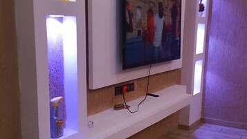 A modern living room with a flat-screen TV mounted on a white entertainment unit.