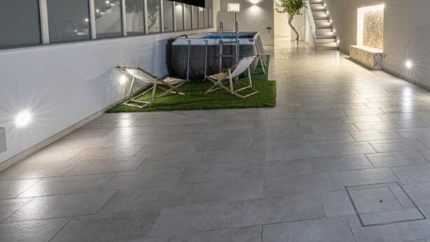 A spacious corridor with a tiled floor, a seating area with a table and chairs, and a staircase leading to an upper level. - Cozy seaside villa a few meters from the beach for couples and families (Tre Fontane)