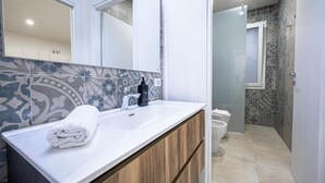 A modern bathroom with a white sink, wooden vanity, and patterned tiles. - Cozy seaside villa a few meters from the beach for couples and families (Tre Fontane)
