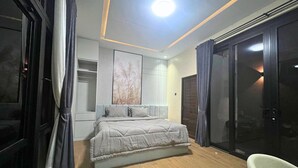 A modern bedroom with a bed, a wardrobe, and a sliding glass door.