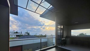 A balcony with a view of the sky and buildings.
