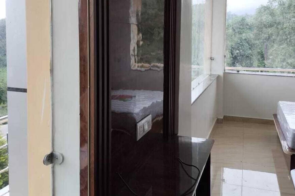 A room with a large window, a wooden cabinet, and a tiled floor.