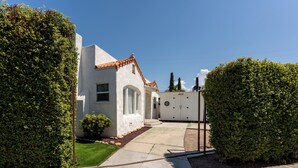 A residential property with a white exterior, a tiled roof, and a paved driveway.
