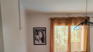 A bedroom with a bed, a desk with a computer, a window with curtains, and a framed picture on the wall. - Charming 3-bedroom house with WiFi, piscine, and AC in welcoming Saint-Raphaël (Saint-Raphaël)