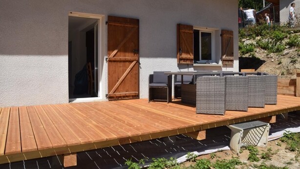 A wooden deck with outdoor furniture, a sliding door, and a view of a hillside. - Family home in the heart of the Tarentaise (Moûtiers)
