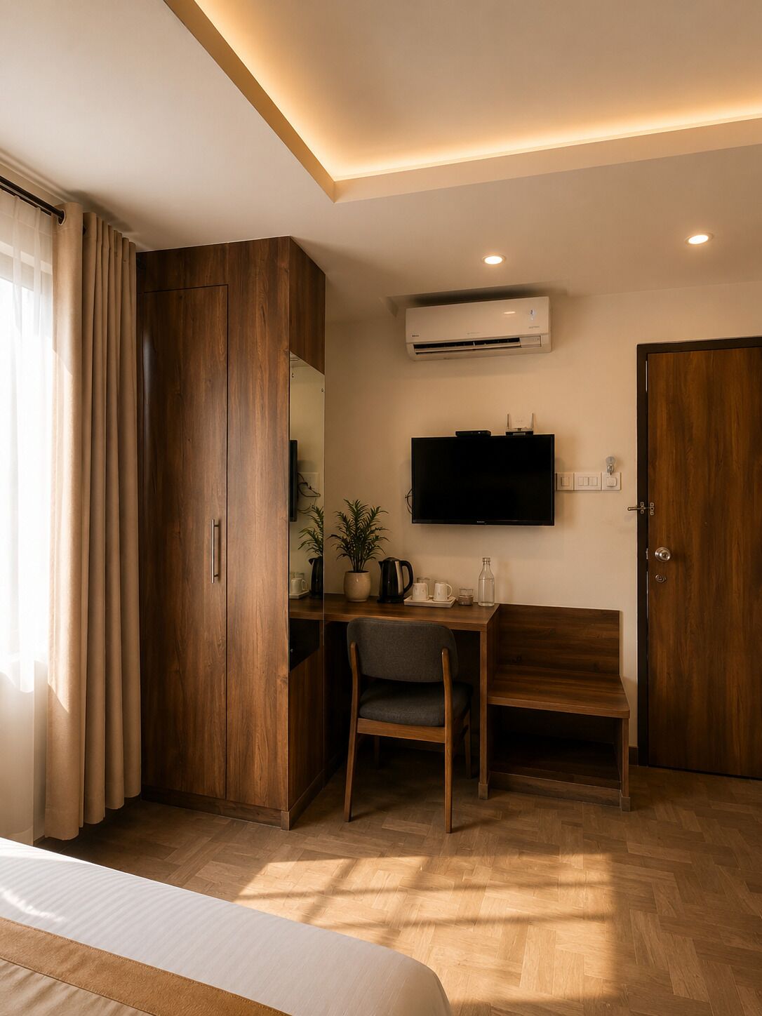 A hotel room with a bed, a desk with a chair, a television, an air conditioning unit, and a wardrobe.