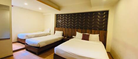 Habitación de hotel con dos camas, suelo de madera y un diseño moderno en el techo.