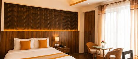 Una habitación de hotel con una cama grande, un escritorio y una silla.