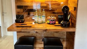 A compact kitchen with wooden cabinetry, a built-in coffee maker, and two bar stools. - Vacation apartment Fietz, Gr. Balcony with mountain view 2 bedrooms Parking lot (Anger)