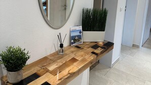 A modern bathroom with a wooden vanity, a round mirror, a potted plant, and a framed picture on the counter. - Vacation apartment Fietz, Gr. Balcony with mountain view 2 bedrooms Parking lot (Anger)