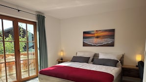 A bedroom with a large bed, a view of the outdoors through a sliding glass door, and a painting of a sunset on the wall. - Vacation apartment Fietz, Gr. Balcony with mountain view 2 bedrooms Parking lot (Anger)