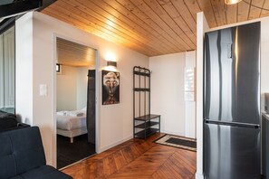A modern kitchen with a stainless steel refrigerator, wooden flooring, and a minimalist design. - Smartstay - Vue panoramique sur Lyon et la saone (Lyon)