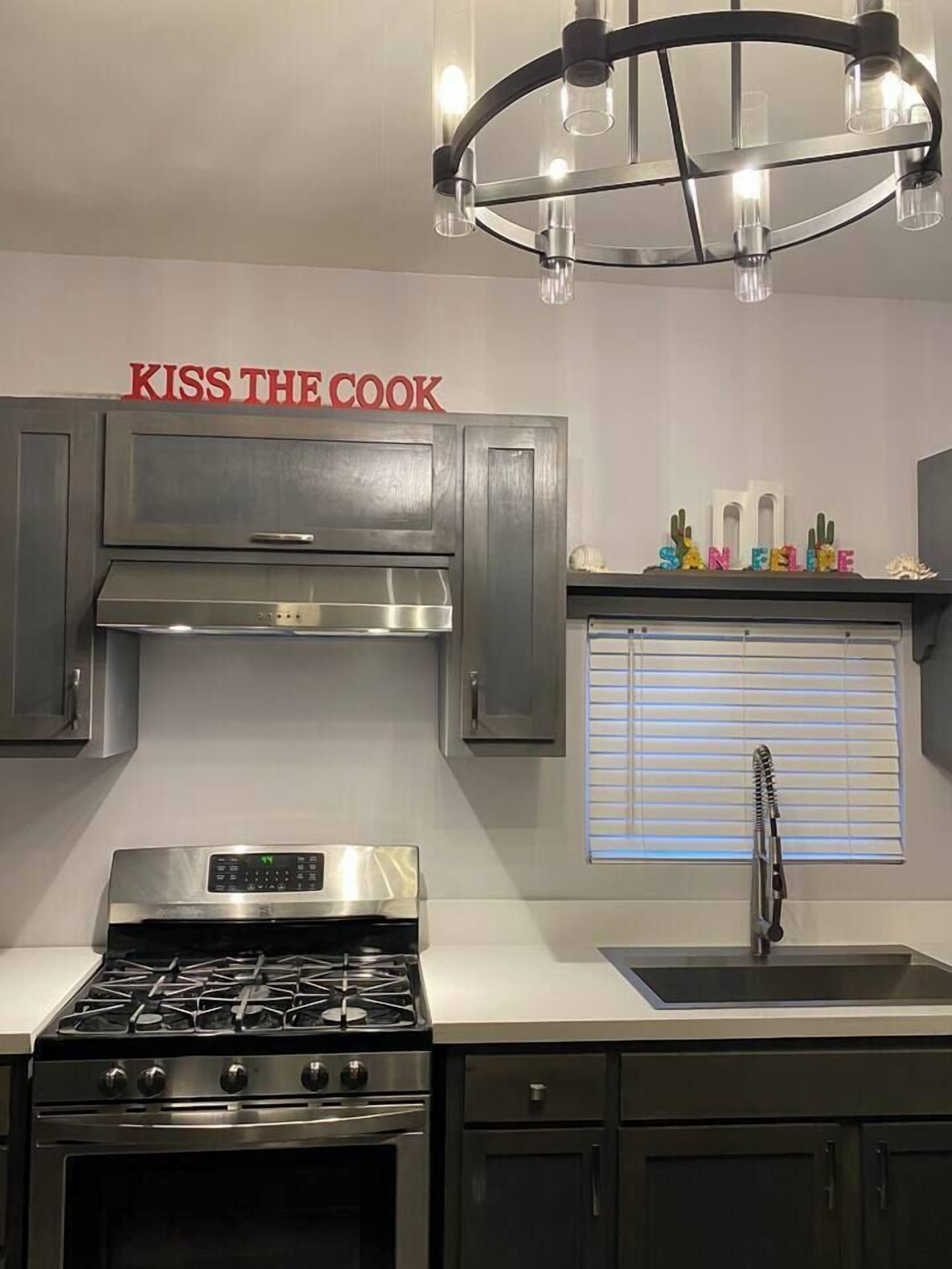A modern kitchen with stainless steel appliances, a gas stove, a built-in oven, and a black faucet.