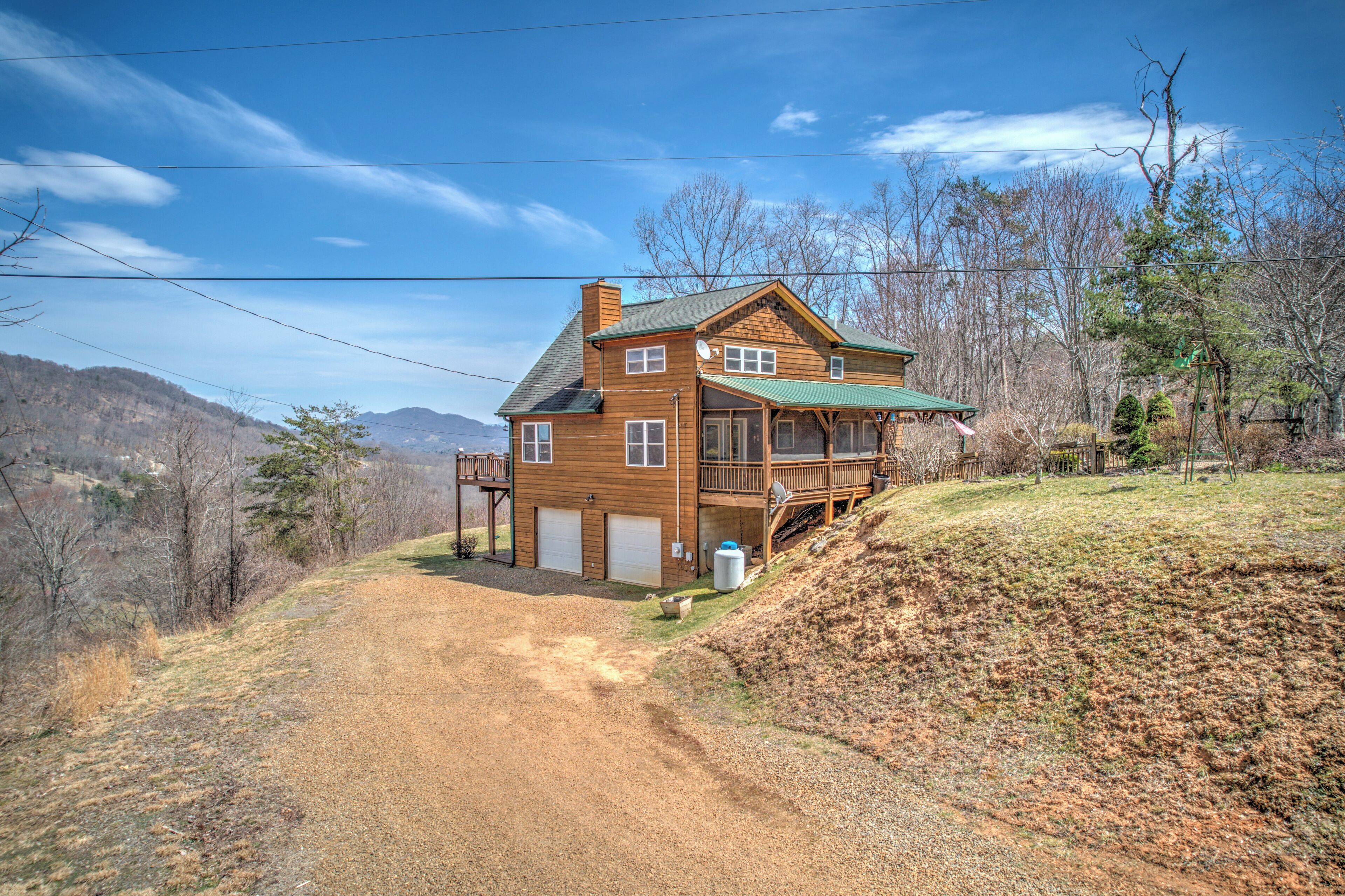 Une maison en bois à deux étages, dotée d’un toit végétalisé, d’une terrasse à l’avant et d’un garage.