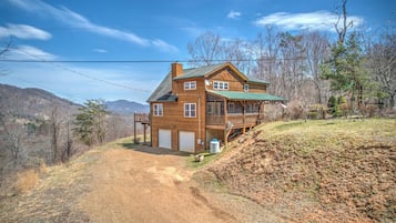 Une maison en bois à deux étages, dotée d’un toit végétalisé, d’une terrasse à l’avant et d’un garage.