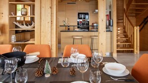 A wooden interior with a dining area, kitchen, and staircase.