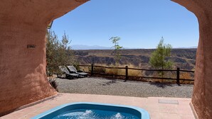 Un jacuzzi con vista a un paisaje montañoso junto a la piscina.