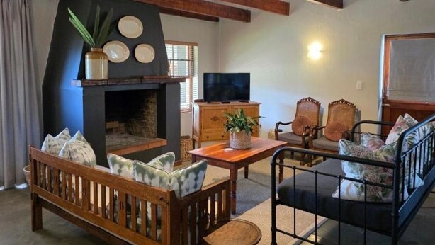 Tunnelmallinen olohuone, jossa on takka, puuhuonekalut ja televisio.