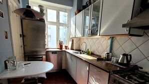 A kitchen with a wooden floor, a stove, cabinets, and a window. - Best location at Vesterbro and close to subway (Copenhagen v)