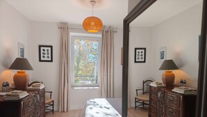 A bedroom with a bed, two nightstands with lamps, a dresser, a window with curtains, and a mirror. - Magnanerie de Sainte Croix (Saint-Hippolyte-de-Caton)