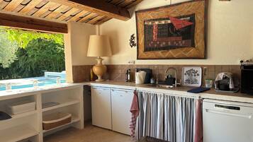 Une cuisine avec un plafond en bois, un grand tableau, un évier et un lave-vaisselle.