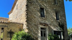 A stone building with a tiled roof, a central entrance, and multiple windows. - Magnanerie de Sainte Croix (Saint-Hippolyte-de-Caton)