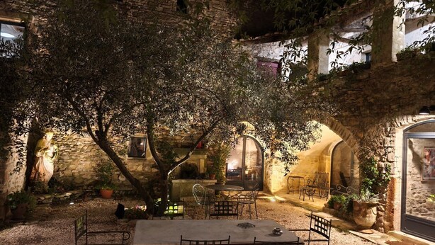 An outdoor patio with a table and chairs, surrounded by stone walls and potted plants. - Magnanerie de Sainte Croix (Saint-Hippolyte-de-Caton)