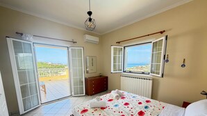 A bedroom with a bed, a dresser, a radiator, and a window with a view.