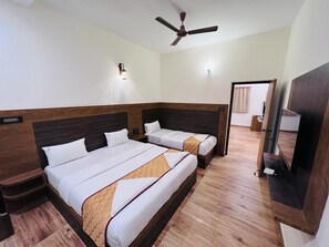 A hotel room with two beds, a ceiling fan, a TV, and a wooden floor. - Park view Yelagiri (Yelagiri)