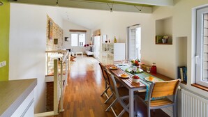 A spacious dining area with a long wooden table, chairs, and a view of a kitchen and living area. - -STONE-Maison de Ville à Concarneau (Concarneau)