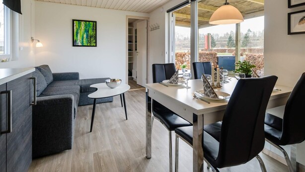 Un espace de vie moderne comprenant un coin repas, un canapé et une vue sur l’extérieur.