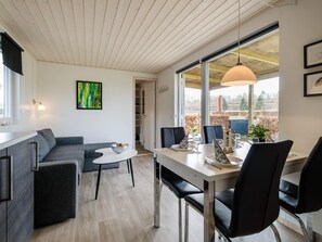 A modern living space with a dining area, a sofa, and a view of the outdoors. - 5 Person Holiday Park Home in Bryrup (Bryrup)
