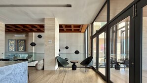 Un intérieur moderne avec un comptoir en marbre, deux chaises noires et une cloison en verre.