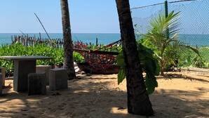 Una spiaggia con palme, un'amaca e una panchina in cemento.