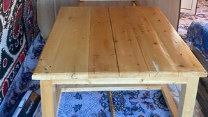 A small, enclosed sleeping area with a wooden table and a mattress.