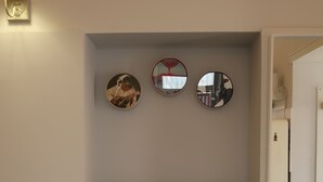Ein modernes Wohnzimmer mit einer Couch, einem Wandspiegel und einer dekorativen Leuchte.