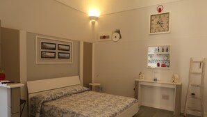 Een slaapkamer met een bed, een bureau, een stoel, een plank met flessen, een klok en een ladder.