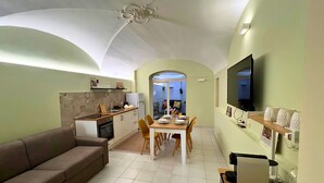 A compact living space with a kitchenette, dining area, and a seating area. - NEW Central Stylish Flat/Private Patio/2min Subway (Catania)