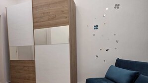 A modern room with a built-in wardrobe, a sofa, and a herringbone-patterned floor. - Modern vacation home for couples and families - central area (Napoli)