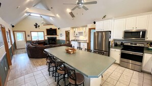 A spacious kitchen with a large island, stainless steel appliances, and a ceiling fan. - The Kite Club - Canal Front, All One level - 4 Bedroom House, Pool, Large Docks (Avon)