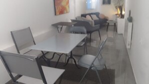 Una sala de estar moderna con comedor, que incluye un juego de sofá, una mesa de centro y una mesa de comedor con sillas.