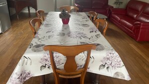 Ein Essbereich mit einem Tisch, der mit einer blumigen Tischdecke bedeckt ist, umgeben von Holzkästen.