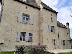 A stone building with multiple windows and doors, featuring a traditional architectural style.
